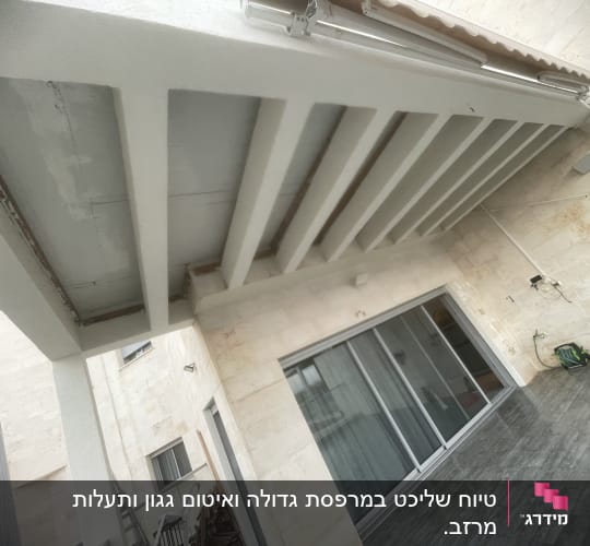 פרגולה מותקנת מעל מרפסת עם דלתות זכוכית